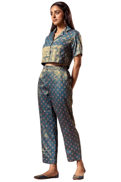 Woman in patterned two-piece outfit posing in studio setting.